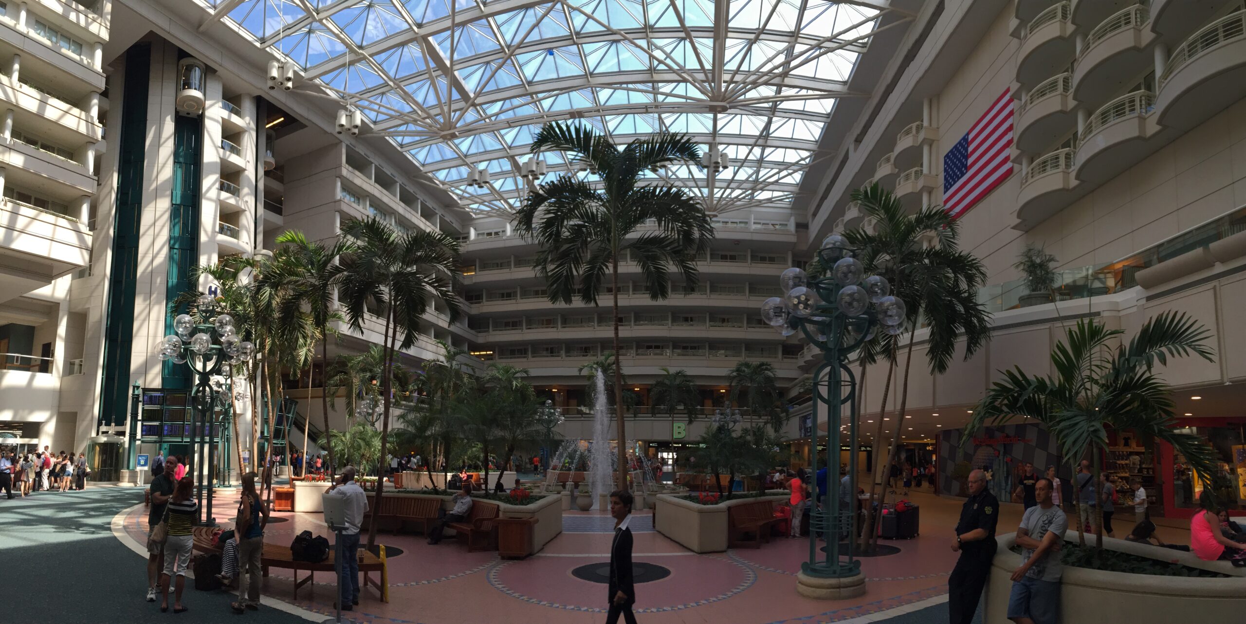 Interior of Miami International Airport terminal with palm trees and travelers in Florida
